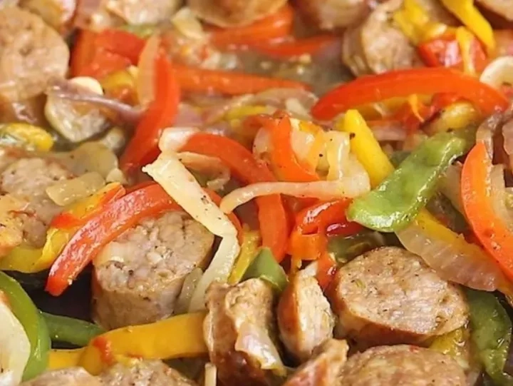Sliced sausages mixed with sautéed red, yellow, and green bell peppers and onions.